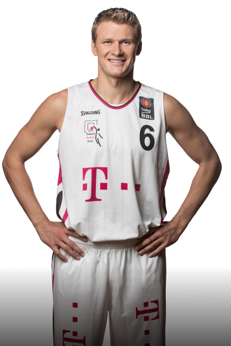 Benas Veikalas - professional basketball player Mortgage Broker Slam Dunk Mortgage Team Viera Melbourne Florida, in a white tank top flexing his muscles and smiling, with a plain background.