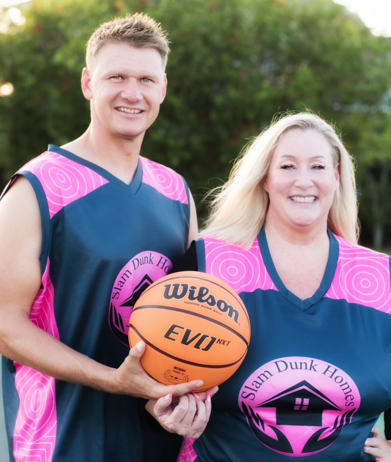 Stacey Sandlin and Benas Veikalas Mortgage Broker Slam Dunk Home Loans Viera Melbourne Florida, with Benas Holding the ball in a both in pink jersey.