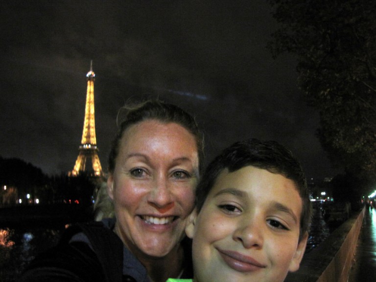 Stacey Sandlin Benas Veikalas Mortgage Broker Slam Dunk Mortgage Team Viera Melbourne Florida, family travels at illuminated Eiffel Tower.” This captivating photo features Stacey Sandlin and her son standing before the iconic Eiffel Tower at night.