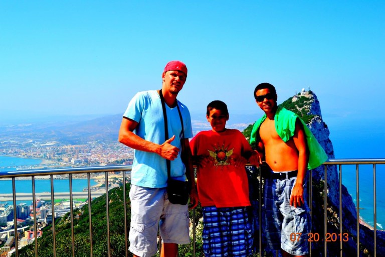 Benas Veikalas Mortgage Broker Slam Dunk Mortgage Team Viera Melbourne Florida, and his sons overlooking coastal cityscape. tanding by a railing, gazing out at a breathtaking view. The backdrop showcases a picturesque coastal city with azure waters stretching into the distance.