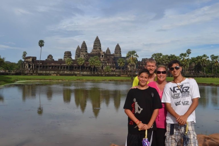 Stacey Sandlin Benas Veikalas Mortgage Broker Slam Dunk Mortgage Team Viera Melbourne Florida, family travels at Angkor Wat temple.” The image depicts three individuals standing in front of the ancient Angkor Wat temple in Cambodia. The temple’s reflection is visible in a serene pond, creating a captivating scene.